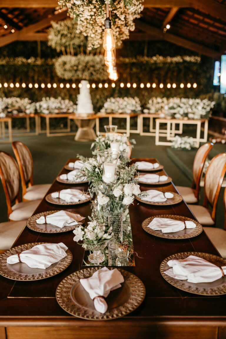 Beautiful wedding reception with elegantly set tables and floral centerpieces in a rustic hall.